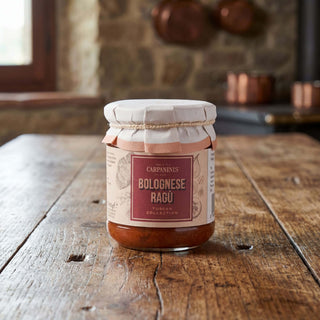 A jar of bolognese ragu on a wooden table