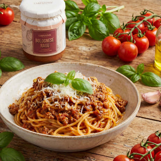 A jar of bolognese ragu next to a bowl of spaghetti