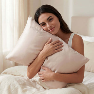 Woman holding a silk pillow with 'Carpaninis' branding in a bedroom setting.
