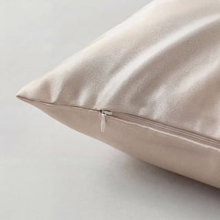Beige silk pillow on a light gray background