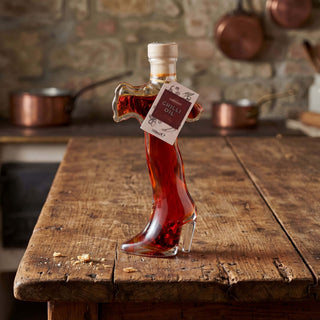 An Italy shaped bottle of chilli oil on a wooden table