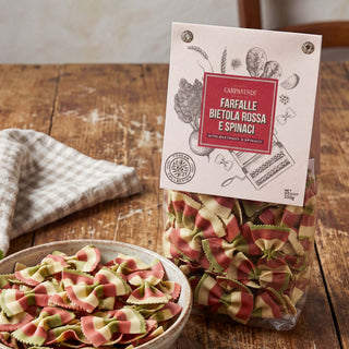 A packet of farfalle pasta on a wooden table