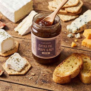 A jar of fig jam opened with a wooden spoon inside