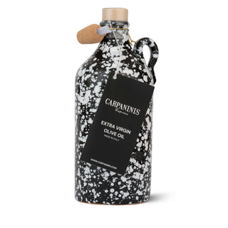 Black and white speckled olive oil bottle with cork stopper and Carpaninis label on a white background