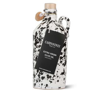 Speckled olive oil bottle with a black label on a white background