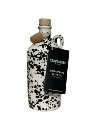 A Carpaninis bottle of olive oil from Italy. Painted white with a black splatter on a white background.