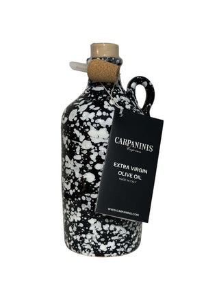 A Carpaninis handmade and handpainted jceramic jar of extra virgin olive oil from Italy. Black with a white splatter of paint.