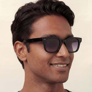 Man wearing dark sunglasses with a neutral background