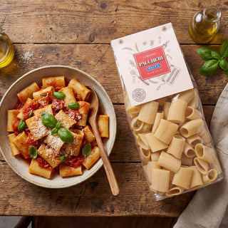 A birds eye view of a packet of Carpaninis paccheri pasta with a prepared bowl