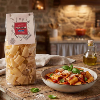 A packet of Carpaninis paccheri pasta next to a prepared bowl in a Tuscan kitchen