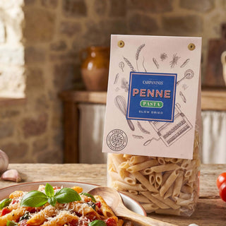 A packet of Carpaninis penne pasta on a wooden table in a Tuscan kitchen