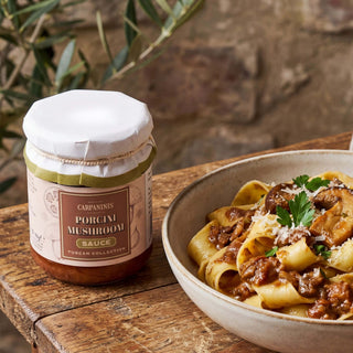 A jar of porcini mushroom sauce on a wooden table