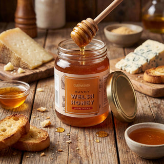 A jar of Carpaninis runny honey surrounded by a cheeseboard