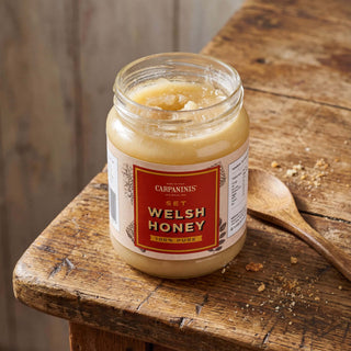 A jar of Carpaninis Welsh set honey on a wooden