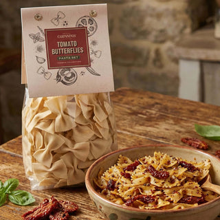 A packet of Carpaninis butterfly pasta next to a prepared bowl