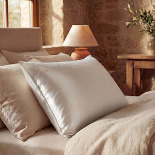 Neatly arranged pillows on a bed in a cozy bedroom setting with soft lighting.