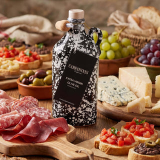 A handmade bottle of olive oil surrounded by a cheeseboard