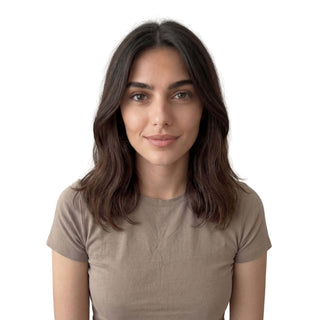 Woman wearing a brown t-shirt against a white background with neat hair