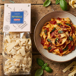 A packet of Carpaninis pappardelle pasta next to a prepared dish