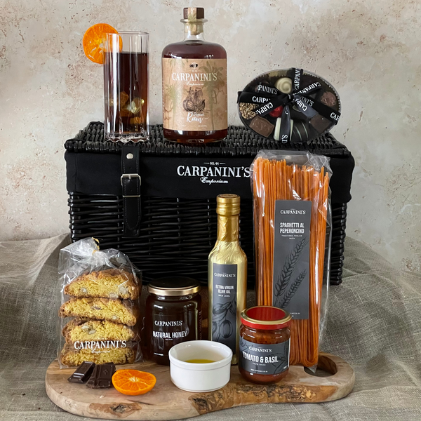 carpaninis wicker hamper with rum bottle glass chocolates cantucci honey olive oil sauce and pasta in black